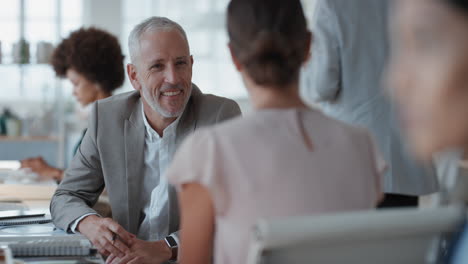 mature businessman chatting to intern discussing job interview colleagues having conversation in office enjoying teamwork