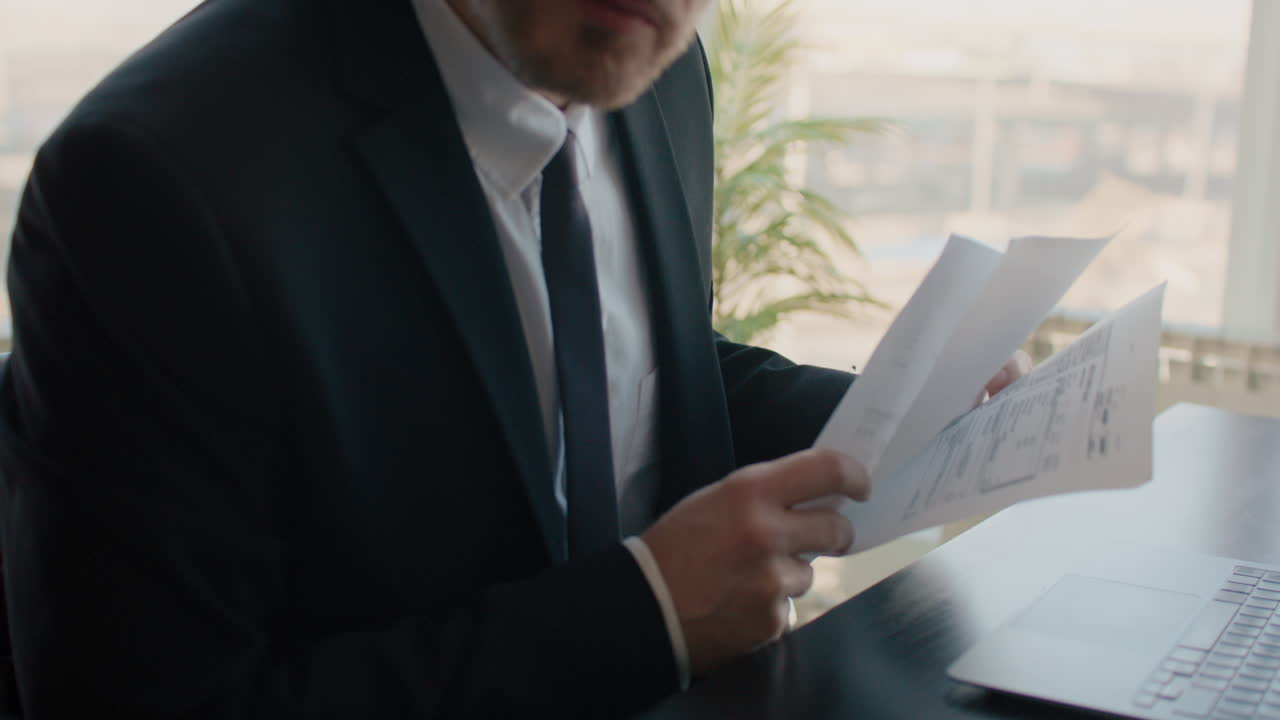 un hombre de negocios revisando documentos en su escritorio.