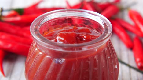 chili sauce in a jar with chili peppers