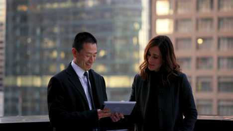 Front-view-of-mixed-race-business-people-discussing-over-digital-tablet-4k