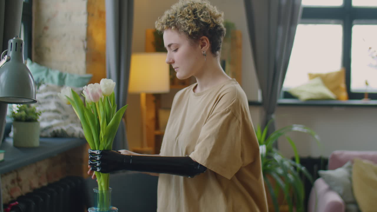 Girl with Prosthetic Arm Putting Flower Bouquet in Vase