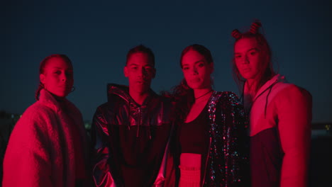 group-of-friends-posing-in-city-at-night-wearing-stylish-urban-fashion-looking-confident-young-people-enjoying-nightlife-with-red-light