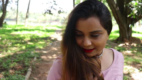 Video-En-Cámara-Lenta-De-Una-Hermosa-Mujer-India-Sonriendo-Y-Mirando-A-La-Cámara-Después-De-Jugar-Con-Su-Cabello