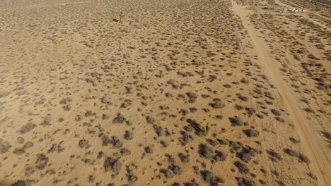 Inclinación-Aérea-Sobre-Una-Comunidad-Desértica-Solitaria-En-El-Desierto-De-Mojave-De-California