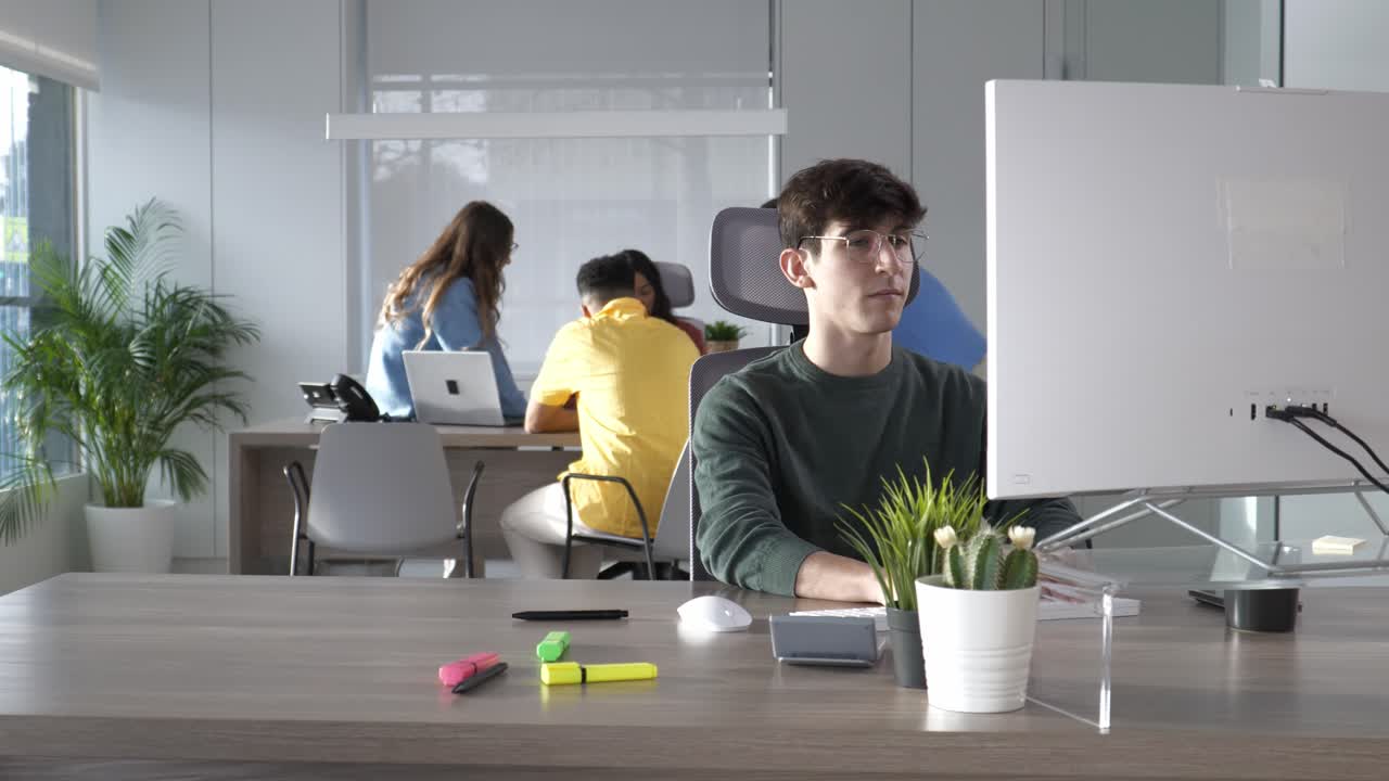 Focused employee working on computer in busy office