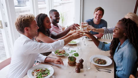 grupo de amigos comiendo en un restaurante juntos haciendo un brindis