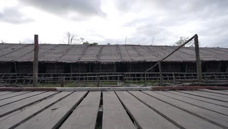 POV-Gesichtspunkt-Beim-Gehen-Auf-Einer-Alten-Holzbrücke-Und-Einem-Haus-In-Der-Indonesischen-Landschaft