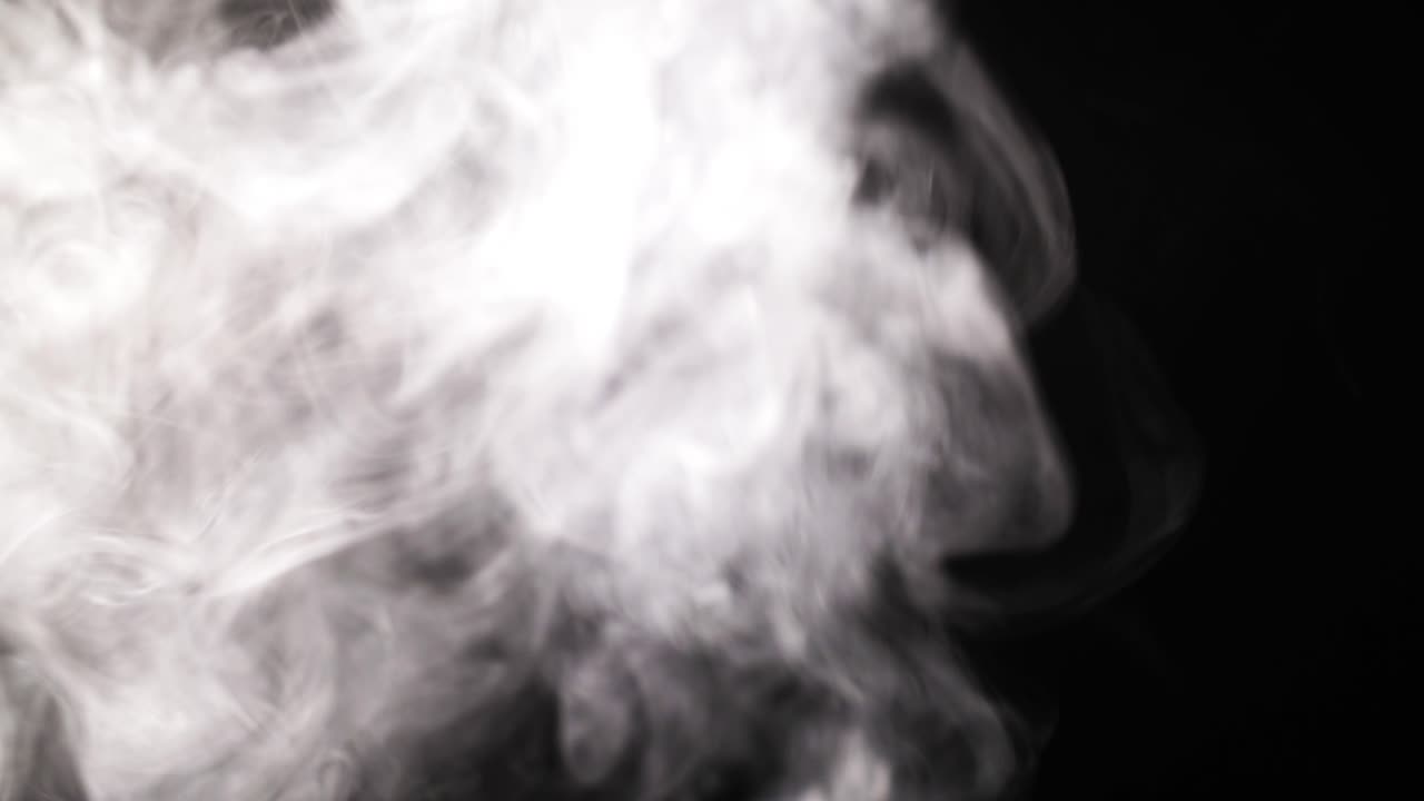 Humo blanco o vapor elevándose y disipándose sobre fondo negro
