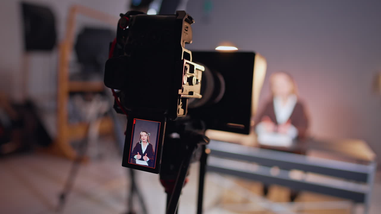 Good-looking Caucasian female on the camera display. Lady talks, gestures for video recorded in studio.