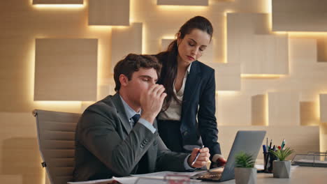 worried colleagues discussing papers looking computer screen at office closeup