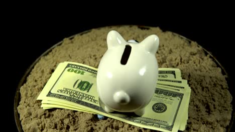 a white piggy bank and dollar bills spins on a black background.