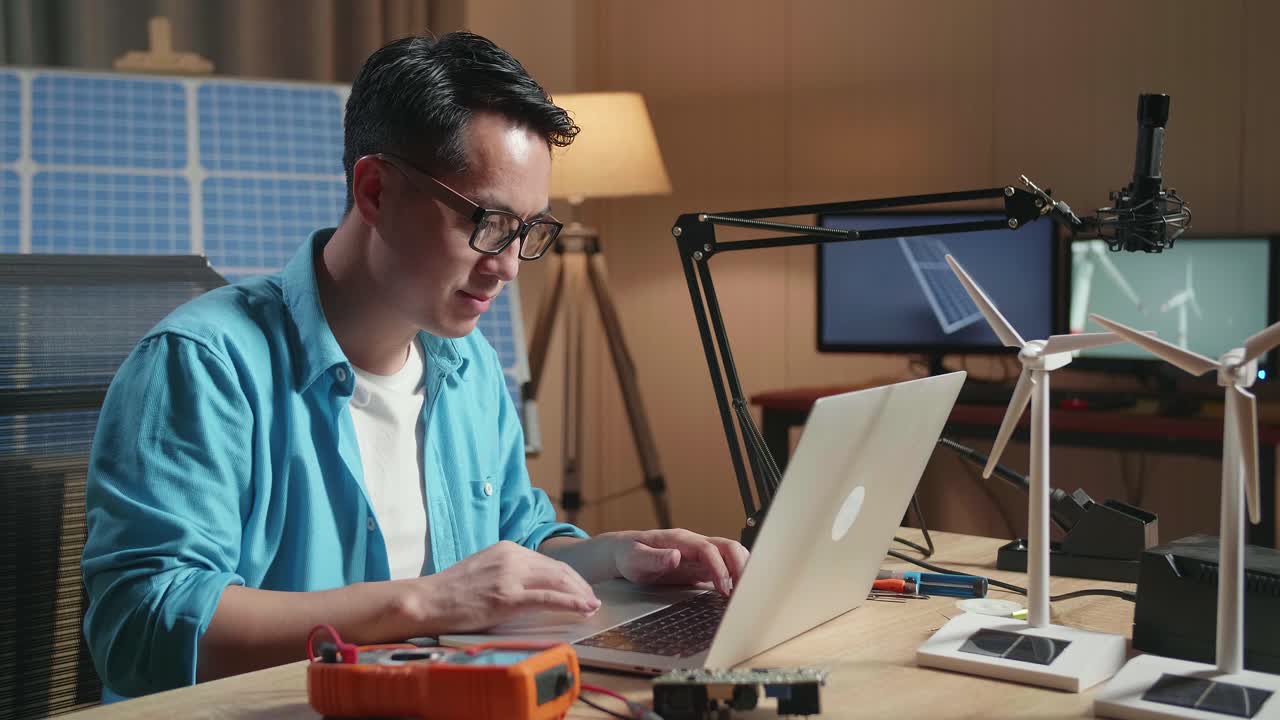 사무실 에서 노트북 에 타이핑 하는 태양 전지 앞 에 앉아 있는 아시아인