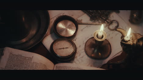 an old compass on the table filled with documents and maps inside the sailing ship cabin