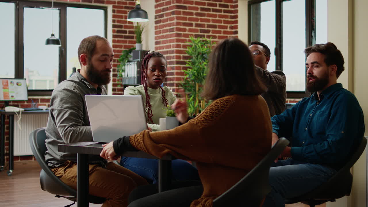 Diverse team of coworkers analyzing research data on laptop