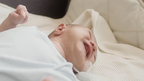 Primer-Plano-De-Un-Lindo-Bebé-Recién-Nacido-Acostado-En-La-Cama-Y-Llorando