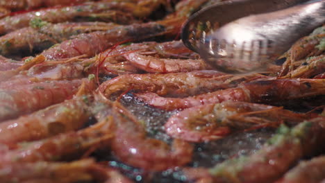 closeup man cooking crawfish on grill. male in barbecuing crayfish with herbs