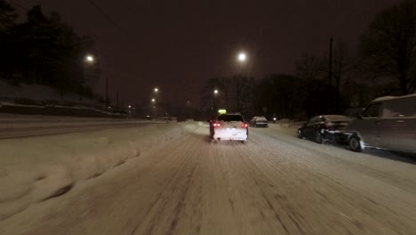 pov driving shot along heavily covered snowy streets with other drivers