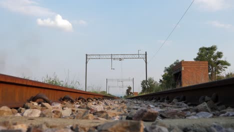 Track-level-view-of-abandoned-railway-line-and-brick-shelter-nearby