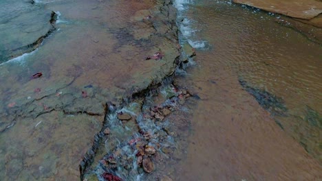 dolly aéreo disparó sobre una pequeña y pacífica cascada en cedar creek en monterey, kentucky, hermoso y colorido fondo rocoso