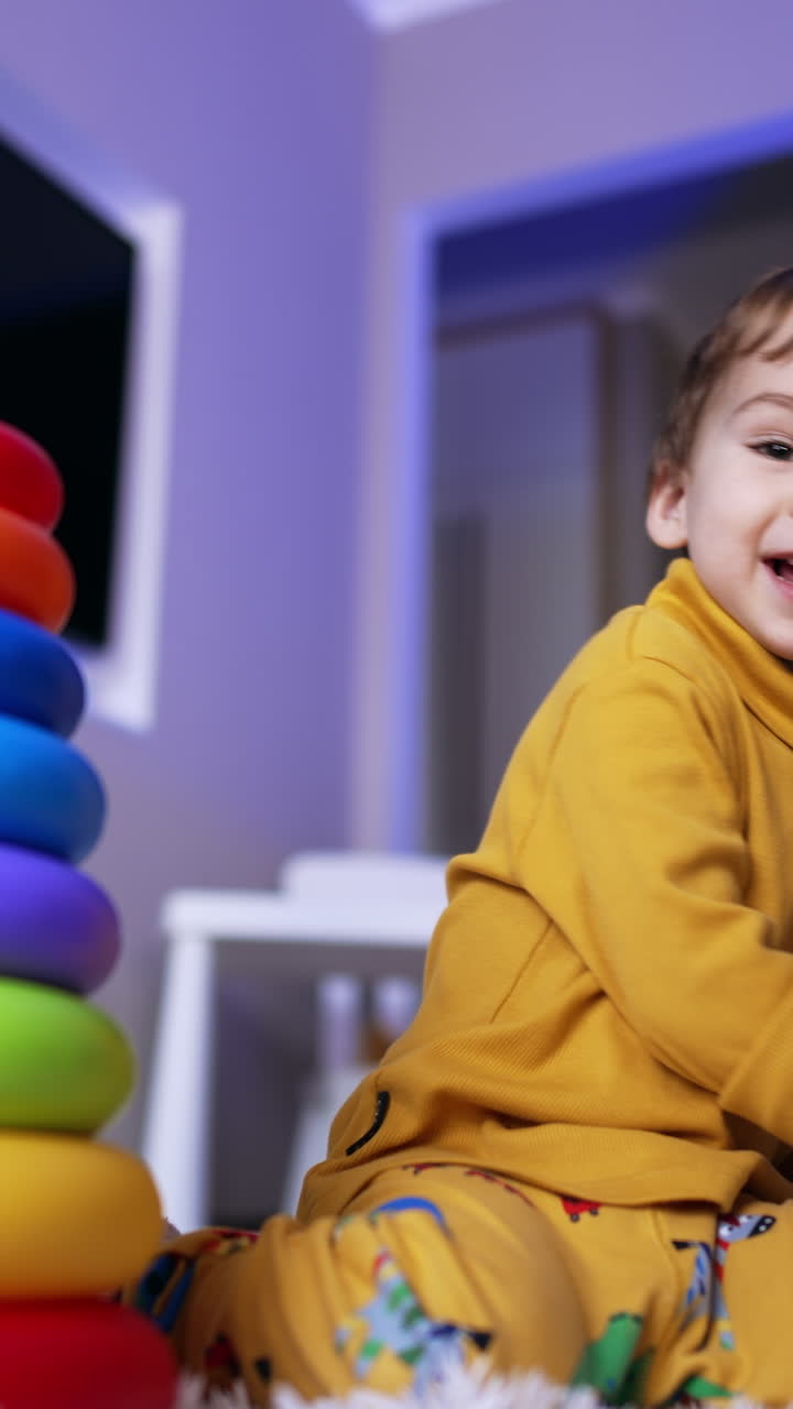 Serious Caucasian toddler assembles the pyramid