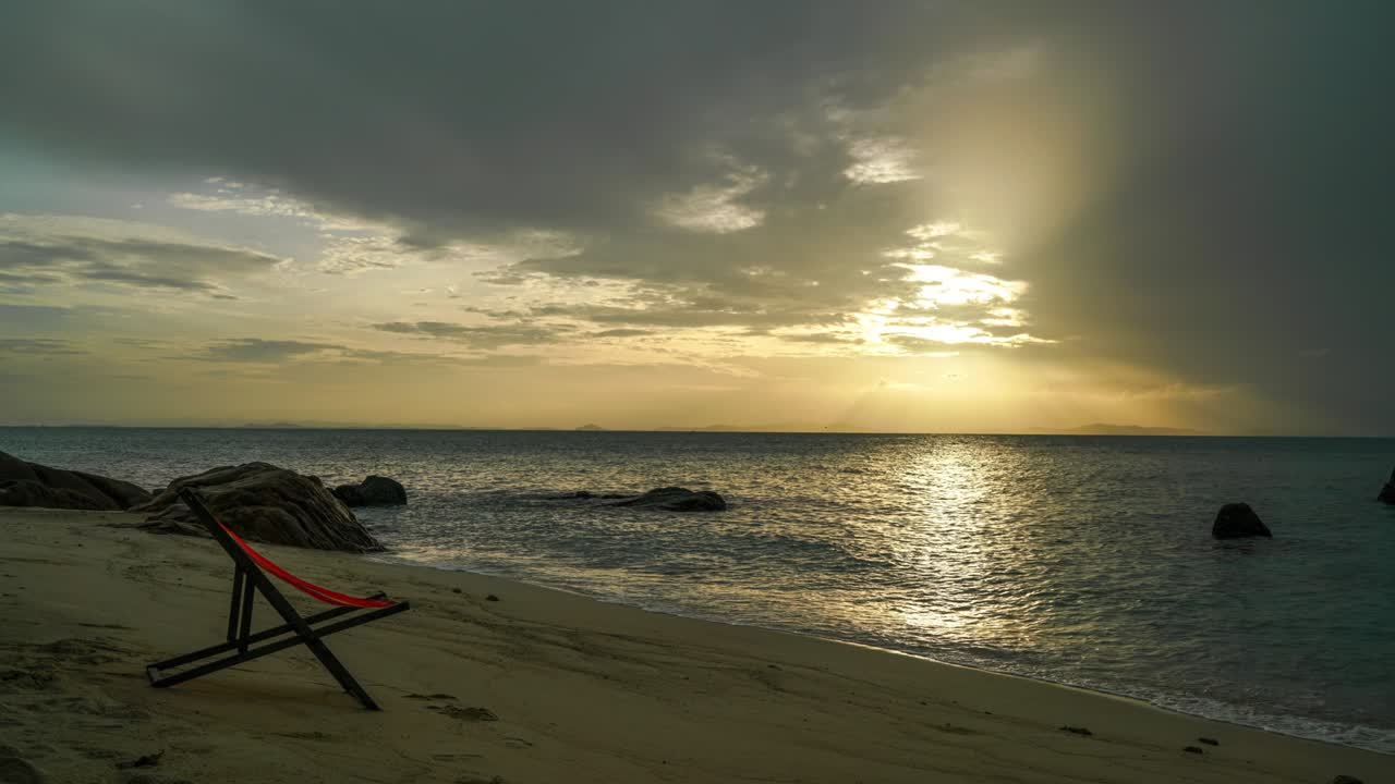 4k time lapse silla cómoda de madera en la playa en el cielo de la mañana y el hermoso mar.