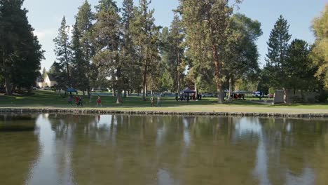 People-walking-along-the-bank-of-Drake-Park-in-Downtown-Bend,-Oregon