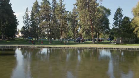 gente caminando a lo largo de la orilla de drake park en el centro de bend, oregon