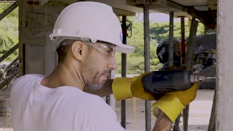 worker drilling inside a building on the construction site