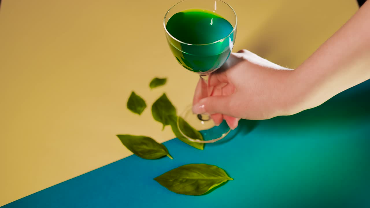 albahaca y bebida verde en un fondo geométrico