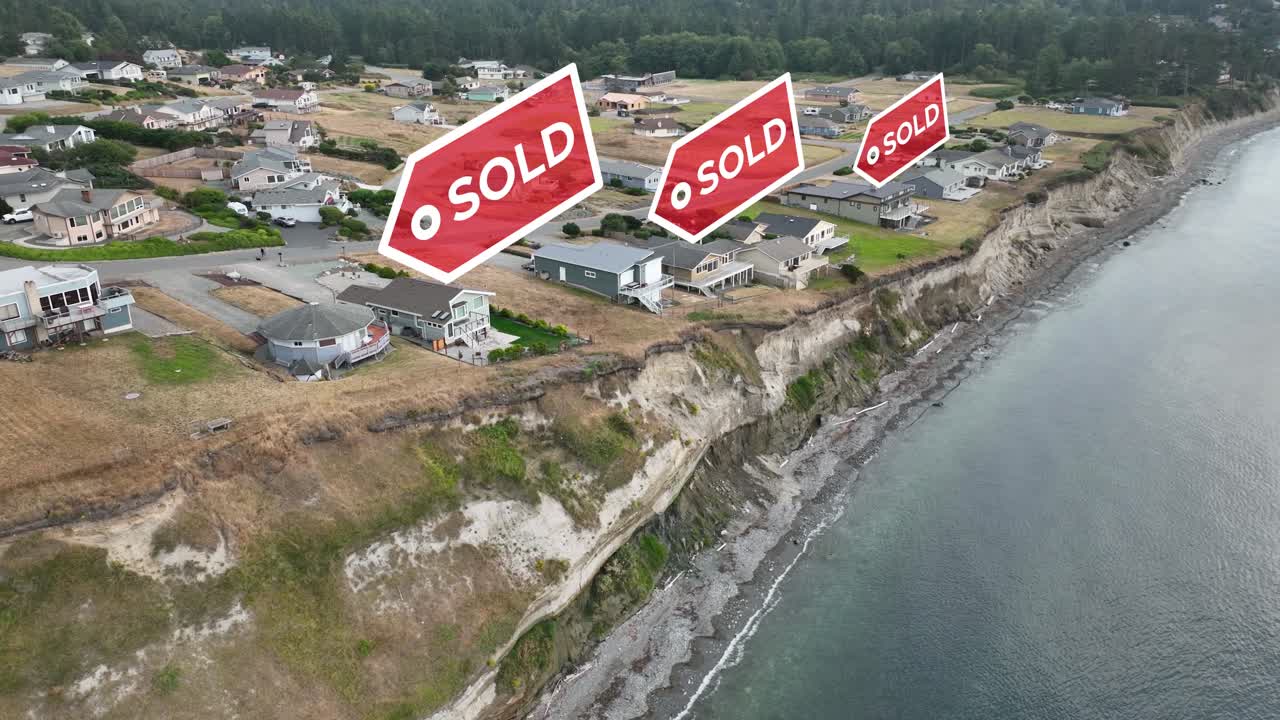 Aerial view of homes with &amp;quot;SOLD&amp;quot; signs animating above them on the coast of the ocean
