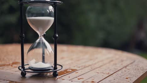 hour glass sand passing through wasting time in garden