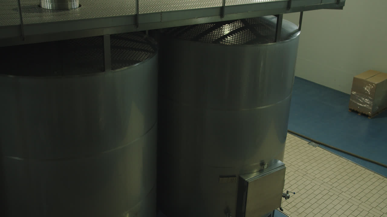 impresionante toma dentro de una fábrica de vino dentro de grandes contenedores metálicos en el sur de españa en 4k