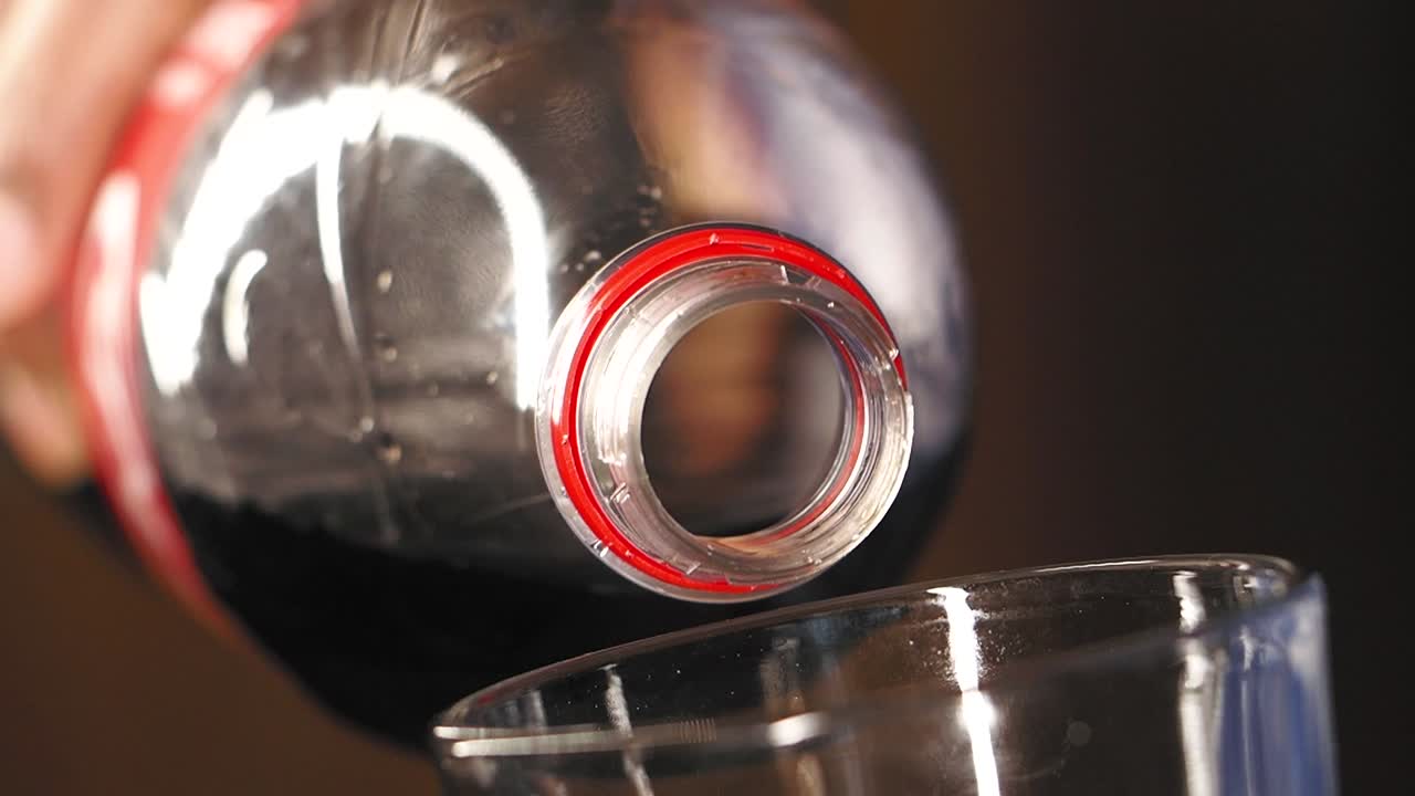 병에서 컵으로 콜라를 부어 넣는 것