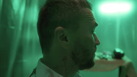 hombre atado con sangre en la cara y la camisa despertando en la sala de tortura