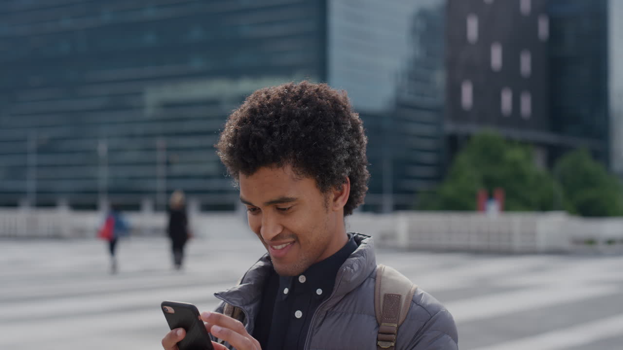 portrait young mixed race business man using smartphone in city texting browsing online messages on mobile phone enjoying professional urban lifestyle slow motion