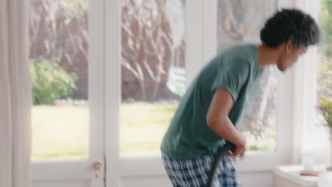 Un-Joven-Feliz-Bailando-Con-Una-Aspiradora-En-Casa-Limpiando-El-Dormitorio-Celebrando-El-éxito-Divirtiéndose-Bailando-El-Fin-De-Semana-Por-La-Mañana-Sintiéndose-Positivo