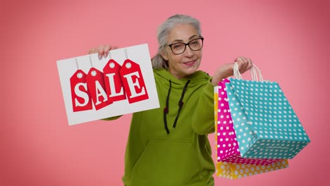 elderly granny woman showing sale inscription banner text, advertising discounts low holidays prices