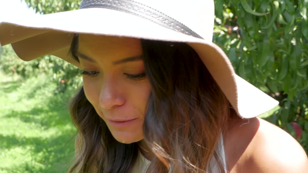 그녀가 잘 익은 복숭아를 크게 한 입 먹은 후 여자의 얼굴에 주스가 흘러내린다