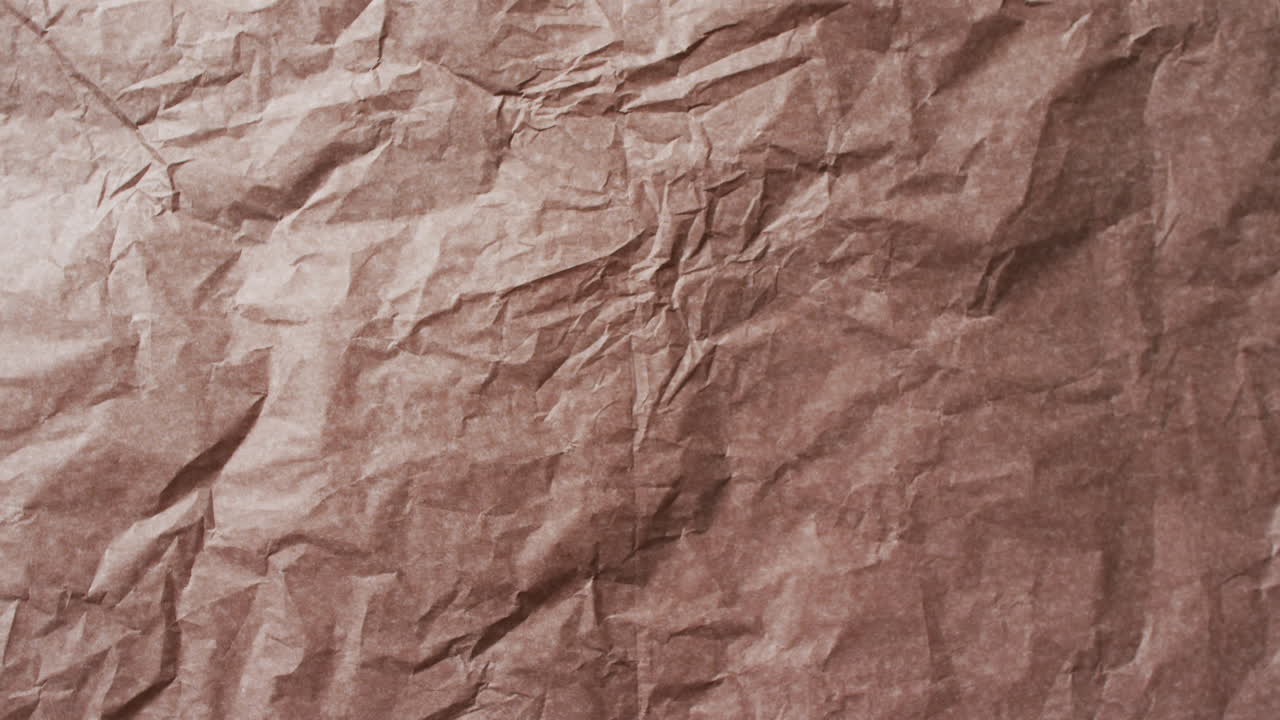 Video of close up of crumpled brown paper texture background