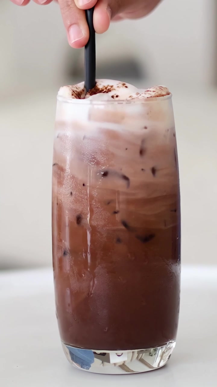 Versamento di latte nel caffè freddo nel tempo