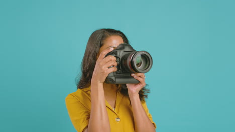 Bewegungsgrafiken-Rund-Um-Eine-Fotografin-Mit-Kamera-Vor-Blauem-Hintergrund-Bei-Aufnahmen-Im-Studio