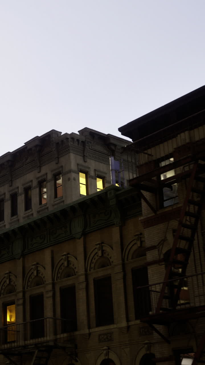 Edificio histórico con ventanas luminosas en un entorno urbano al atardecer