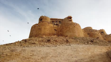 low tracking shot of jaisalmer fort, with birds, rajasthan, india