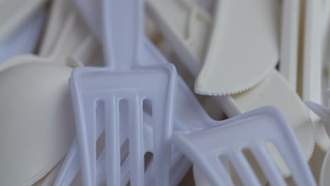 close up pan over a bunch of single use plastic utensils