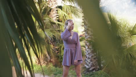 woman in purple dress in a palm tree garden