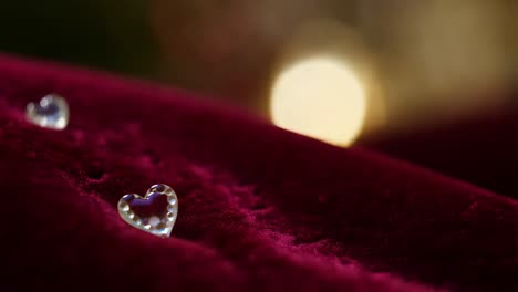 two clear heart-shaped crystals on velvet fabric