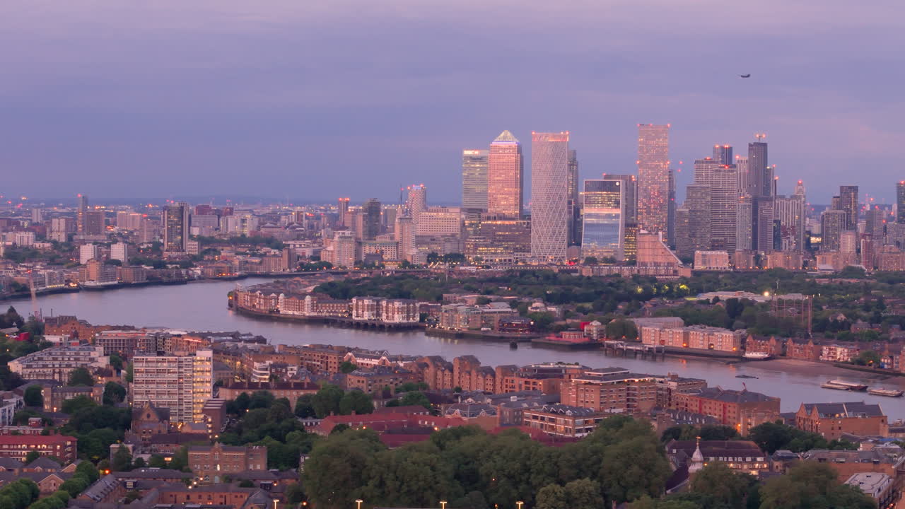 Twilight aerial of Canary wharf as chinook chopper flies over London skyline