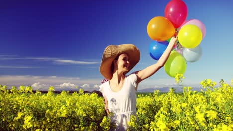 Romantic-couple-holding-colorful-balloons-and-running-in-mustard-field