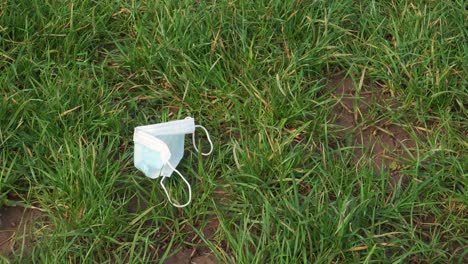 mascarilla facial de grado médico de 4k desechada en un campo verde, desechos biológicos