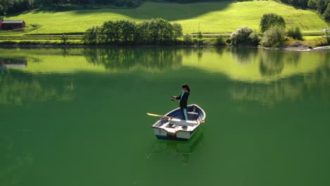 la mujer en el barco atrapa un pez en el giro en noruega.